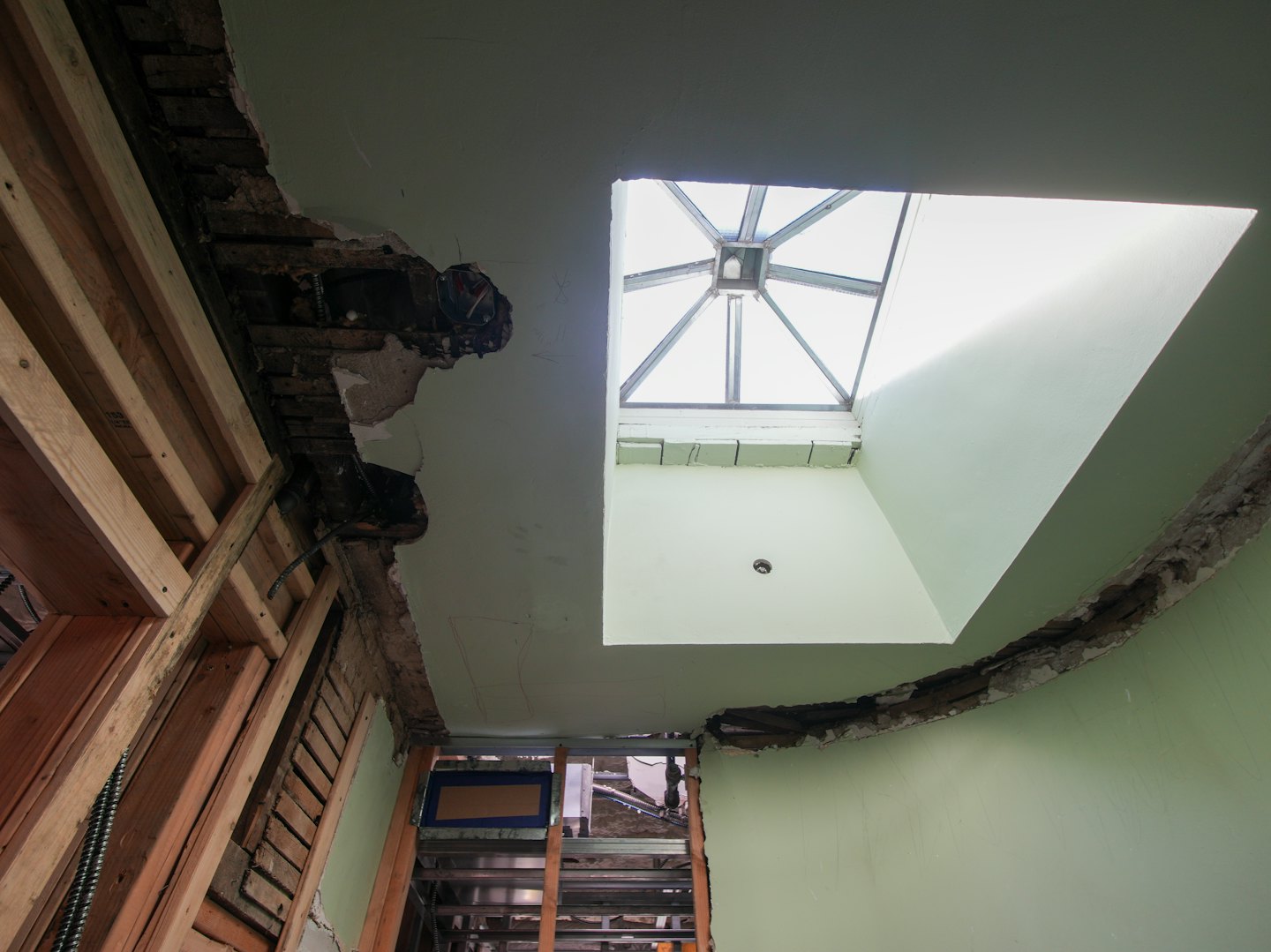 Stanza ristrutturata con travi in legno a vista e lucernario sul soffitto.