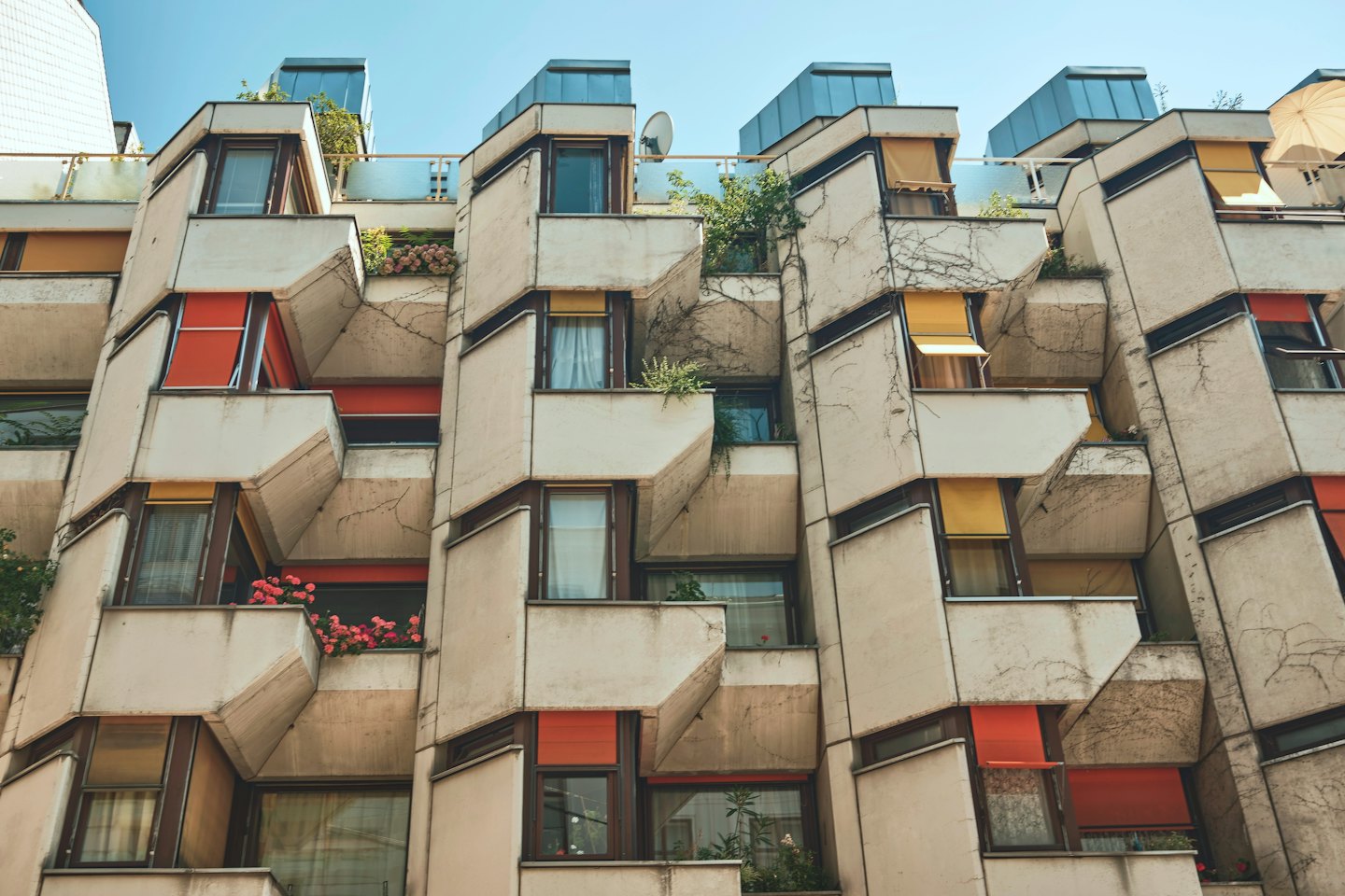Edificio residenziale moderno con pareti geometriche e piante sospese.