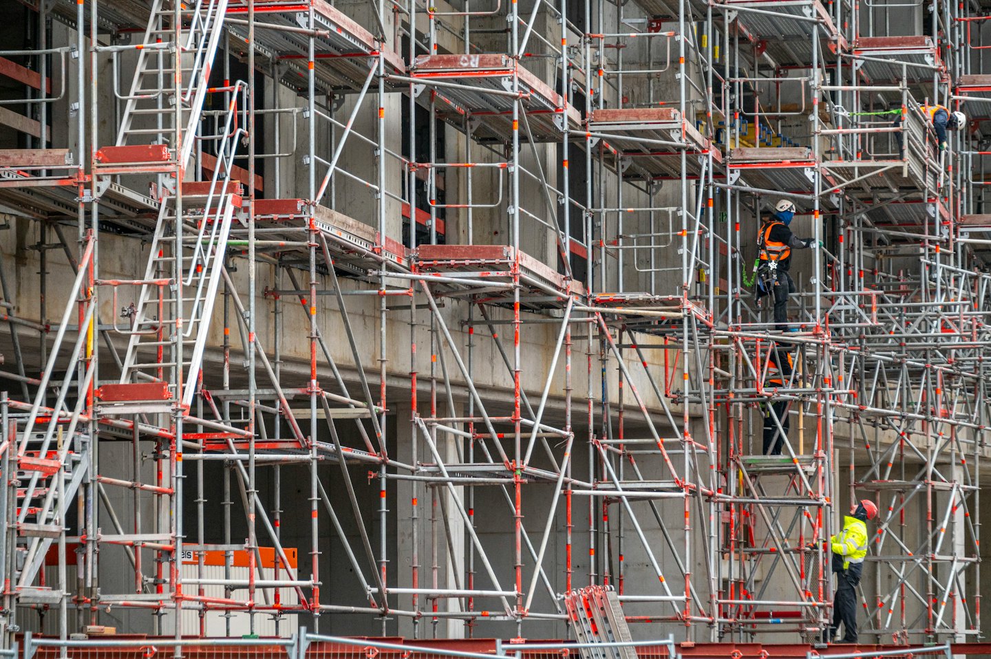 Operai edili in tenuta di sicurezza su un ponteggio vicino a un edificio.